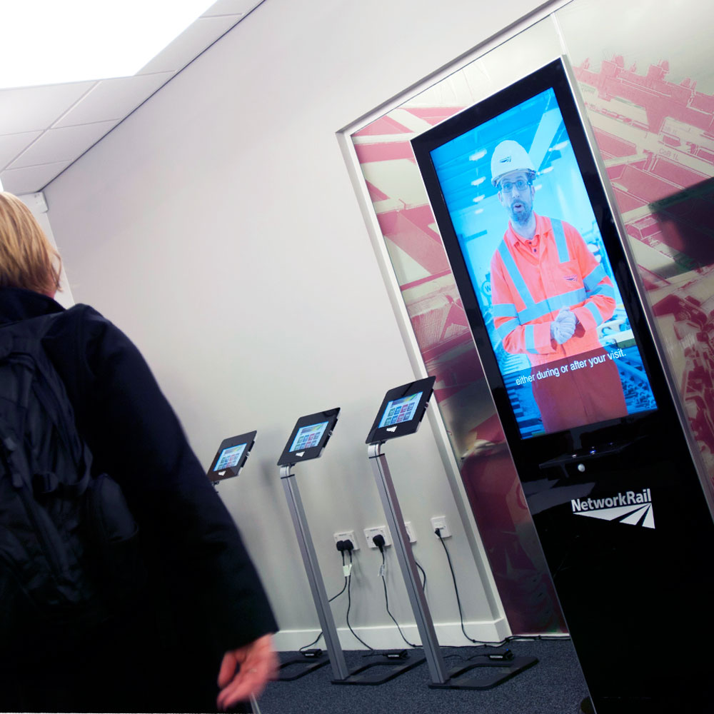 visitors having an induction infront of our  life size visitor induction kiosk